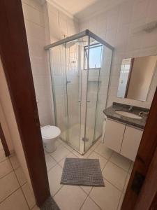 a bathroom with a shower and a toilet and a sink at Flat a Beira Mar in Caraguatatuba