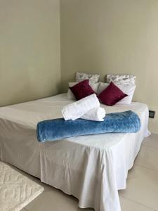 a bed with a blue and white blanket on it at Aquasaints Sandton Logde in Johannesburg
