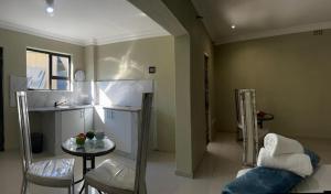 a kitchen with a table and chairs in a room at Aquasaints Sandton Logde in Johannesburg +43 photos