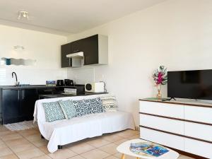 a living room with a couch and a kitchen at Breathtaking Bora Bora Lagoon View Studio in Bora Bora