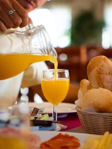 a person is pouring orange juice into a glass at Rialgarve in Faro