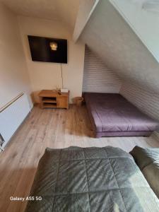 a attic room with a bed and a tv at Hanna house in Belfast
