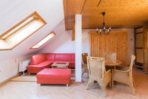 een woonkamer met een rode bank en een tafel bij Apartments Ilmtal-Jena in Jena