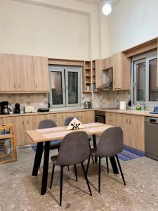 a kitchen with a wooden table and four chairs at Nóstos Home in Kos