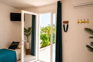 a bedroom with a sliding glass door leading to a balcony at Monolocale elegante con design moderno e atmosfera tropical chic in Nardò