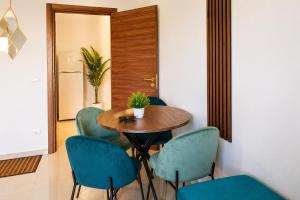 a dining room with a wooden table and blue chairs at Monolocale elegante con design moderno e atmosfera tropical chic in Nardò