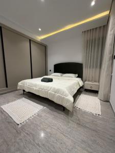 a bedroom with a large bed with white sheets at Luxueux T2 à Ain Zaghouen in El Aouina