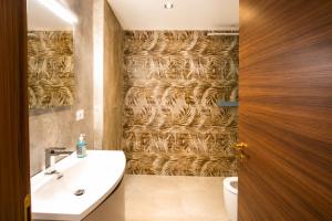 a bathroom with a sink and a wall covered in grass at Monolocale elegante con design moderno e atmosfera tropical chic in Nardò +1 photo