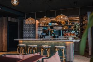a bar with stools and chandeliers at Lily Country Club in Klofta