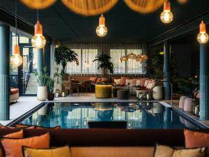 a hotel lobby with a swimming pool and a restaurant at Lily Country Club in Klofta