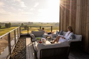two people sitting on a balcony with a view of a field at Lily Country Club in Klofta +174 photos