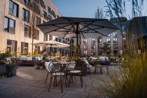 an outdoor patio with tables and chairs with umbrellas at Lily Country Club in Klofta