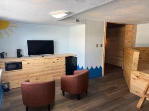 a room with two chairs and a flat screen tv at Lake lawn inn in Pana +31 photos