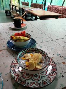a table with two plates of food and a bowl of fruit at La Shamana - Ecological Concept in Jungle in Cahuita