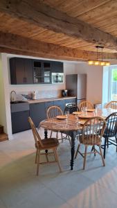 a dining room with a table and chairs and a kitchen at la clé de la rance in Plouër-sur-Rance