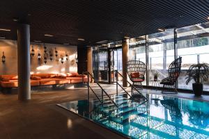 a hotel lobby with a swimming pool and chairs at Lily Country Club in Klofta