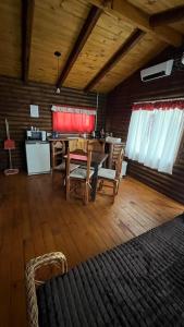 a dining room with a table and chairs in a room at Cabañas La Silvanita in Balcarce
