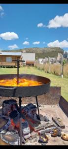 a fire pit with a pizza oven and a fire at Cabañas La Silvanita in Balcarce