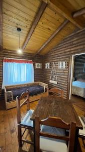 a room with a table and a bed in a cabin at Cabañas La Silvanita in Balcarce