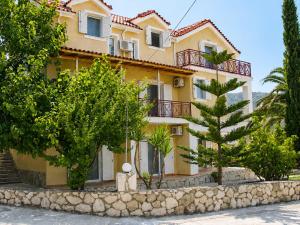 a yellow house with trees in front of it at Elichri Theros Studios in Katelios