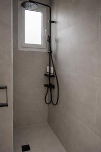 a shower in a bathroom with a window at Elichri Theros Studios in Katelios +35 photos