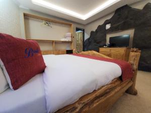 a bedroom with a large bed with a rock wall at Brooks Lodge in Nakuru