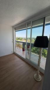 a living room with a floor to ceiling windows and a lamp at appartement mérignac avec parking in Mérignac