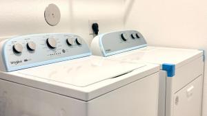 two washing machines sitting next to each other in a laundry room at Luxe Haven in Richmond