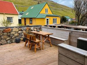 a wooden table and chairs on a wooden deck at Hvanngarðs Smáttan by Stóra in Dalur