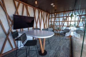a room with a table and chairs and a tv at Courtyard by Marriott Tuxpan Veracruz in Tuxpan de Rodríguez Cano