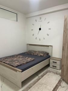 a bedroom with a bed and a clock on the wall at Piad Apartman in Bar