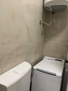 a small bathroom with a white refrigerator and a sink at Piad Apartman in Bar +8 photos