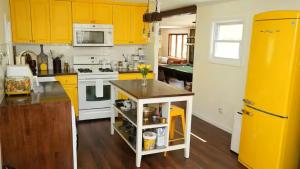 a kitchen with yellow cabinets and a yellow refrigerator at Nemandua Catskills: Hot Tub+Fire Pit+Pool Table+EV in Lanesville