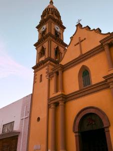 a church with a clock tower on top of it at Jovis Hotel - Lujo Cultural in Villa Aldama