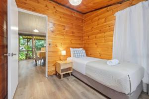 a bedroom with a bed and a desk in a room at Orewa Motor Lodge in Orewa
