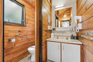 a bathroom with a sink and a toilet at Orewa Motor Lodge in Orewa +35 photos