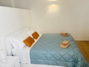 a bedroom with a bed with blue sheets and orange pillows at Sky House Sant'Orsola in Bergamo