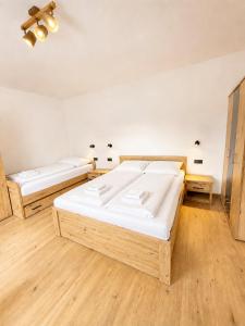 two beds in a room with wooden floors at M3-Apartmány in Martin