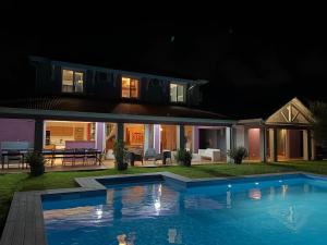 a house with a swimming pool at night at Villa d'architecte avec piscine in Saint-François +9 photos