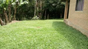 a yard with green grass next to a building at Chácara chalé in Juquitiba +2 photos