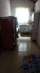 a kitchen with a sink and a refrigerator and a window at Chácara chalé in Juquitiba