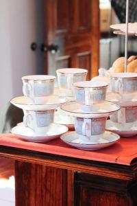a group of cups and saucers on a table at Willough Bed and Breakfast in Conshohocken