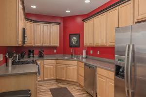 a kitchen with wooden cabinets and a stainless steel refrigerator at 2 Bedroom Mountain View Condo with Private Hottub in Girdwood +18 photos