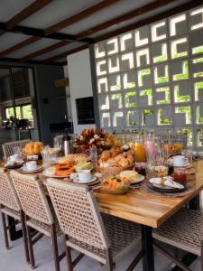 a wooden table with food on it with chairs at Villa Egeu Praia da Pipa in Pipa