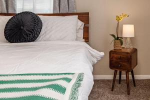 a bedroom with a white bed and a table with a lamp at Historic Downtown Deco Queen Studio in Anchorage
