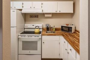 a kitchen with white cabinets and a stove and a microwave at Historic Downtown Deco Queen Studio in Anchorage +14 photos