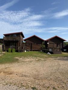a couple of log homes sitting on top of a field at Sara Riverside Cottage in Ulcinj +23 photos