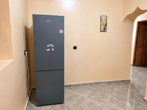 a refrigerator in the corner of a room at Sahara Desert Apartment with Camel Tours & Free WiFi in Merzouga
