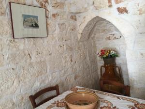 a dining room with a table with a vase of flowers at Trullo L'ulivo in Ostuni