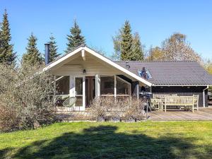 a house with a porch and a bench in front of it at 4 star holiday home in Græsted in Græsted